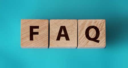 FAQ sign made of wood on an ocean blue table.の写真素材
