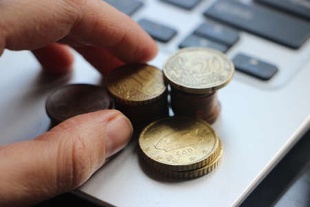 Financial and Business Growth concept, Close up Of Businessman Hand Count and Put Money Coins To Stack Of Coins on computer keyboard. Online trading.の写真素材