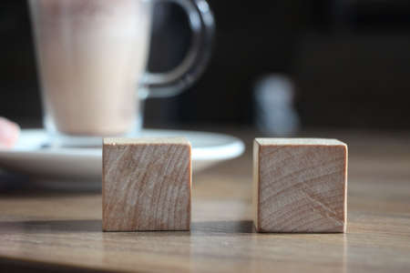 Two wooden cubes with cacao cup. Selective focus. Choise concept.