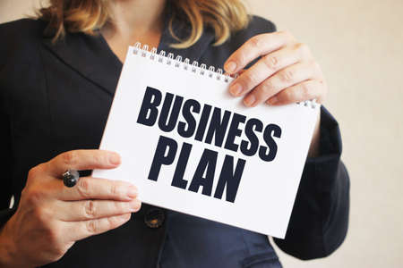 Businesswoman holds a notebook with Business Plan words in her hands. Business and Financial conceptの写真素材