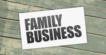 Card with text FAMILY BUSINESS on old wooden table outdoors, top view. Business model concept.の写真素材