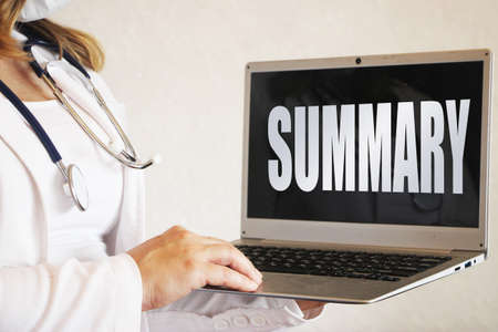 Female doctor holding laptop showing word summary on black. Healthcare concept