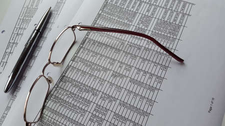 Financial report, glasses and pen. Balancing the Accounts business concept.