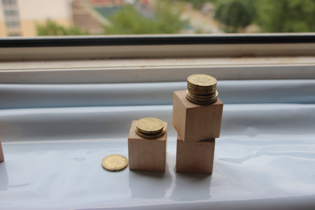 Wooden cubes with coins put into stacks. Business or personal savings investment concept.