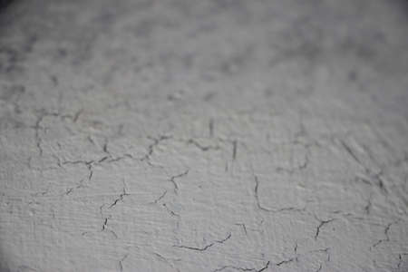 a cracked white gray concrete wall surface background texture.の写真素材
