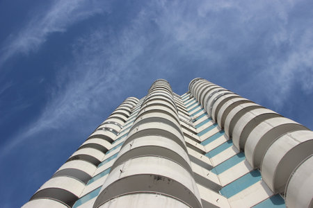 A dwelling apartments, under blue sky with easy clouds, bottom view.