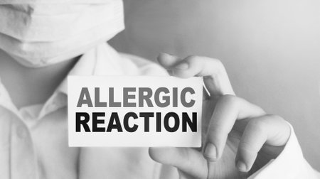 Words allergic reaction on medical card in Doctor's hand. Medicine healthcare concept.の写真素材
