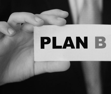 Plan B words on card in hand of businessman wearing suit and tie. Alternative business concept.