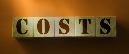 Costs word on wooden blocks with letters on red background. Business expenses value concept.の写真素材