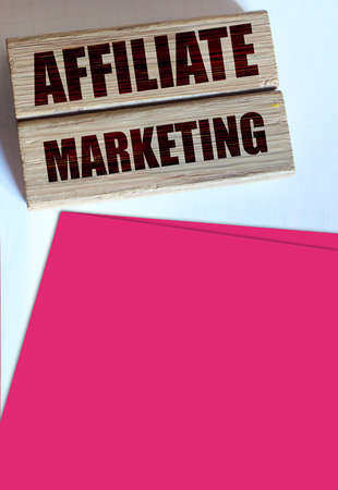 Affiliate marketing typed on a wooden blocks, leather wallet, coins and pen. Referral marketing business concept.の写真素材