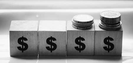 Wooden blocks with dollar signs and coins. Concept of wealth or profit.の写真素材