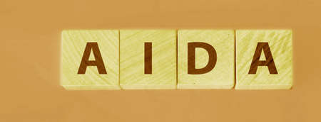 Four wooden cubes with letters AIDA meaning Attention Awareness Interest Desire Action. Business...