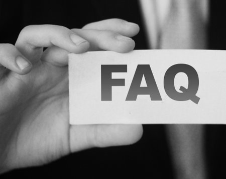 Closeup on businessman holding a card with text FAQ , business concept image with soft focus background.の写真素材