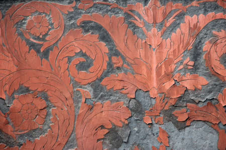 Gray and orange teracotta fresco ornament on ancient wall in Victorian style.