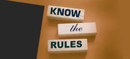 Know the rules word on wooden blocks isolated on dark gray background. business process regulation concept.の写真素材