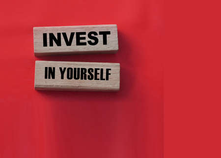 Invest In Yourself words on wooden blocks on red. Education and self motivation concept.の写真素材
