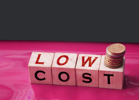 Low cost words on Wooden blocks and coins stack. Sale discount reselling business concept.の写真素材