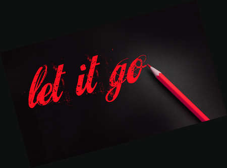 Let it go words written with a yellow pencil on black. Forgiveness, future planning and new life beginning concept.の写真素材