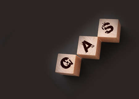 Gas -word on wooden cubes with letters on black. Energy gas oil economy concept.