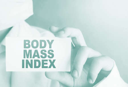 A doctor in medical clothing shows a card with the text Body mass Index Medical concept.の写真素材
