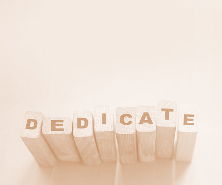 Word Dedicate on a row of wooden blocks. Devotion dedication love concept.の写真素材