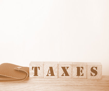 Taxes word on wooden blocks and wallet on table. Taxation and fees business concept.の写真素材