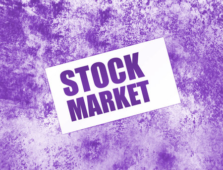 STOCK MARKET words on card on wooden table. Business concept.の写真素材