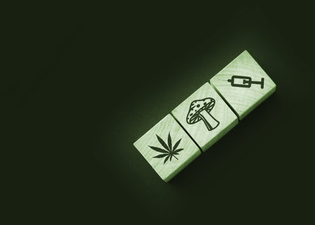 Drugs icons on natural wooden cubes. Cannabis leaf, mushroom and syringe on wooden blocks. Drug Abuse addiction prevention and awareness, healthcare medical rehab concept.の写真素材