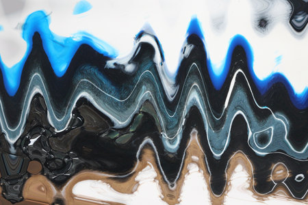 Colorful splash of blue, white, black and silver acrylic ink drops blending and mixing with each...