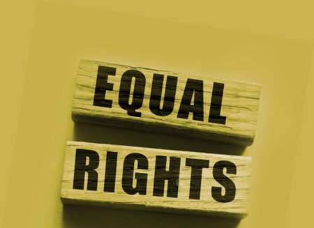 Equal rights words on wooden blocks on yellow background. Gender equality concept.の写真素材