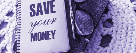text Save Your Money on the cover of notebook, glasses and pen. Business concept for keep your savings in bank or stock to protect it .の写真素材