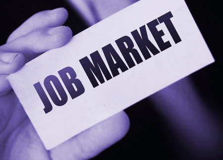 Businessman holds a card with the text Job Market. Business concept.の写真素材
