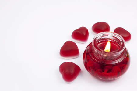 Red candle with hearts on a white backgroundの写真素材