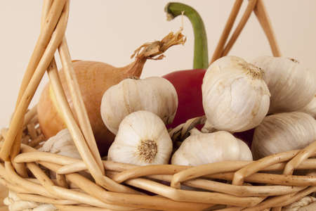 Garlic, onion and red pepper in wicker basketの写真素材