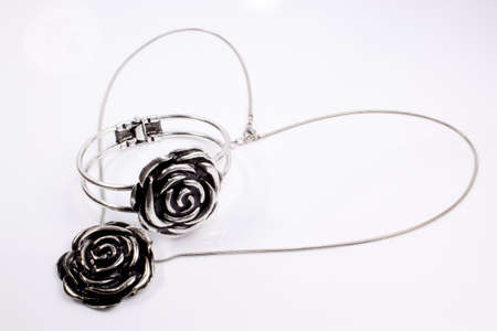 Silver jewelry with a heart shaped chain on a white backgroundの写真素材