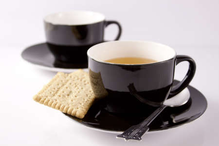 A cup of green tea and biscuit on a white backgroundの写真素材