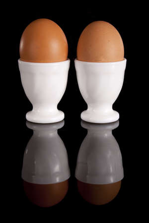 Two eggs in the shell on a black backgroundの写真素材