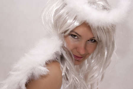 Beautiful woman dressed as angel on a white backgroundの写真素材