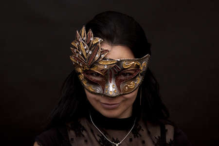 Beautiful woman in mask on a black backgroundの写真素材