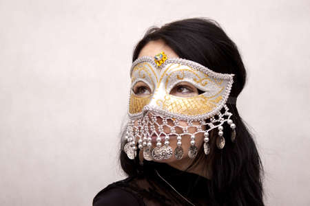 Woman wearing venetian mask on a white backgroundの写真素材