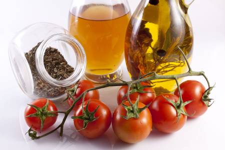 Olive oil, oregano and cherry tomatoes on a white backgroundの写真素材