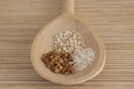 Grits and rice on wooden spoonの写真素材