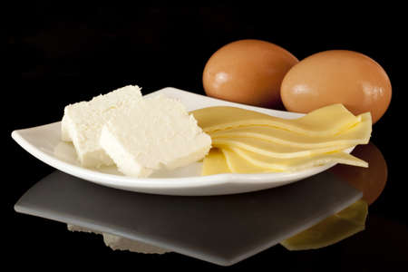 Cheese, cottage and eggs on a black backgroundの写真素材