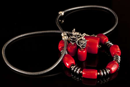 The red bracelet and earrings on a black backgroundの写真素材