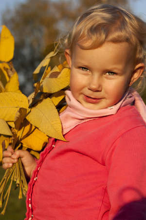 Beautiful girl with yellow leaves in the parkの写真素材