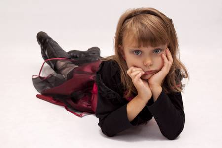The girl in red dress lying on white backgroundの写真素材