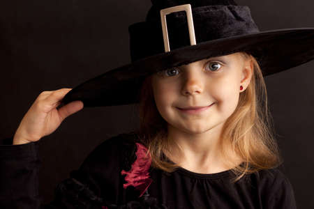Beautiful girl with black hat on a black backgroundの写真素材