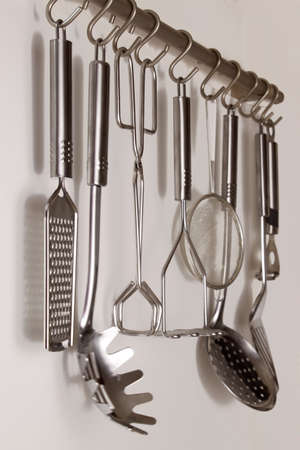 Kitchen railing with metal spoons useful for cookingの写真素材