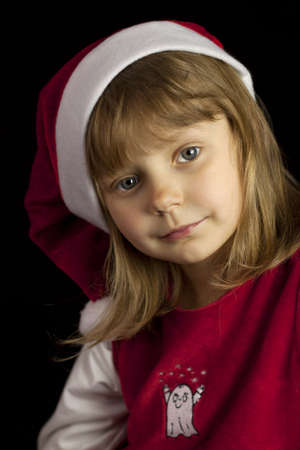 Pretty girl in a red dress Santa Clause on a black backgroundの写真素材