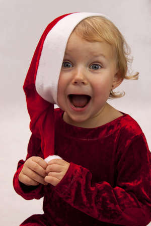 Laughing child in red dress and cap on a white backgroundの写真素材